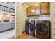 Laundry room with modern washer and dryer, wood cabinets, and wood floors at 14150 Foothill Ln, Golden, CO 80401