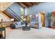 Bright living room featuring vaulted ceiling, wooden beams, staircase, and comfortable seating at 14150 Foothill Ln, Golden, CO 80401