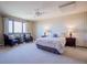 Bright main bedroom with a ceiling fan, large windows, and two sitting chairs at 14150 Foothill Ln, Golden, CO 80401