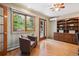 Office area featuring wood floors, built-in shelves, french doors, and a comfortable chair at 14150 Foothill Ln, Golden, CO 80401