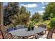 Outdoor dining area with table and seating provides relaxation with lush green surroundings at 14150 Foothill Ln, Golden, CO 80401