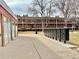 Brick apartment building exterior with mailboxes, well-maintained grounds, and a grassy common area at 6800 E Tennessee Ave # 351, Denver, CO 80224