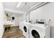 Well-lit laundry room with multiple commercial-grade washers and dryers on wood-look floors at 6800 E Tennessee Ave # 351, Denver, CO 80224