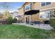 Backyard patio features stylish seating, umbrellas for shade, and a lush green lawn at 2736 Poplar Grove Pl, Castle Rock, CO 80109