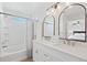 Well-lit bathroom featuring double sinks, marble countertops, and a bathtub and shower combination at 2736 Poplar Grove Pl, Castle Rock, CO 80109