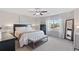 Bright bedroom featuring large window, ceiling fan, upholstered bench, and neutral decor at 2736 Poplar Grove Pl, Castle Rock, CO 80109