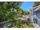 Lush backyard oasis featuring stone pathway, a white deck, beautiful greenery and an AC unit at 8679 Apache Plume Dr, Parker, CO 80134