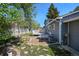 Wood deck leading to garden with stone pavers, manicured lawn, and privacy fence at 8679 Apache Plume Dr, Parker, CO 80134