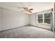 Bedroom with ceiling fan, plush gray carpeting, and bright window at 8679 Apache Plume Dr, Parker, CO 80134