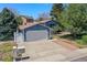 Charming two-story home features a large driveway, attached two-car garage, manicured lawn, and mature trees at 8679 Apache Plume Dr, Parker, CO 80134