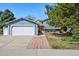Charming blue two-story home features a well-manicured lawn, mature trees, and an attached two-car garage at 8679 Apache Plume Dr, Parker, CO 80134