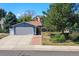 Charming blue two-story home features a well-manicured lawn, brick walkway, and an attached two-car garage at 8679 Apache Plume Dr, Parker, CO 80134