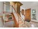 Inviting home foyer with hardwood floors, elegant staircase, stylish mirror and a wood door at 8679 Apache Plume Dr, Parker, CO 80134
