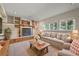 Cozy living room with a fireplace, built-in shelves, and large windows at 8679 Apache Plume Dr, Parker, CO 80134