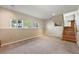 A simple carpeted living room with natural light and a staircase at 8679 Apache Plume Dr, Parker, CO 80134