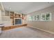 A cozy carpeted living area with a fireplace, built-in shelves, cabinets, and well-lit with multiple windows at 8679 Apache Plume Dr, Parker, CO 80134