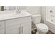 Well-lit bathroom featuring a vanity with quartz counters, toilet, and a tub with tiled walls at 6571 N Malaya St, Aurora, CO 80019