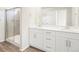 Bathroom with double sinks, white cabinets, and glass door shower at 6571 N Malaya St, Aurora, CO 80019