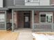 Inviting brick front porch with sturdy railings and sleek black front door entrance at 6571 N Malaya St, Aurora, CO 80019