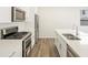 Modern kitchen with stainless steel appliances, light wood floors, and white cabinets at 6571 N Malaya St, Aurora, CO 80019