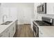 Bright kitchen featuring white cabinetry, stainless steel appliances, and quartz countertops at 6571 N Malaya St, Aurora, CO 80019