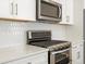 Close-up of a kitchen with stainless steel oven, microwave, and white tile backsplash at 6571 N Malaya St, Aurora, CO 80019