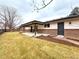 Spacious backyard featuring manicured lawn, mature trees, and a covered patio at 6586 W Leawood Dr, Littleton, CO 80123
