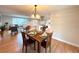 Sunlit dining area with hardwood floors flowing into the adjacent living room and modern kitchen at 6586 W Leawood Dr, Littleton, CO 80123