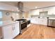 Modern kitchen with stainless steel appliances, white cabinetry and a large island at 6586 W Leawood Dr, Littleton, CO 80123