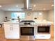Modern kitchen island with stainless steel appliances open to the living area with lots of light at 6586 W Leawood Dr, Littleton, CO 80123