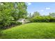 Spacious backyard with lush greenery, featuring a storage shed and mature trees at 12167 E Exposition Ave, Aurora, CO 80012