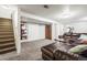 Spacious basement with a large couch, storage space, and stairs leading to the upper level at 12167 E Exposition Ave, Aurora, CO 80012