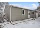 Charming single-story home featuring neutral siding, white trim, and a well-maintained front yard, partially covered in snow at 10763 Lewis Cir, Broomfield, CO 80021