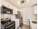 An updated kitchen features stainless steel appliances, mosaic backsplash, and white cabinets at 10763 Lewis Cir, Broomfield, CO 80021