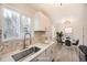 Modern kitchen with white cabinets, stainless steel sink, and stylish backsplash, complemented by a cozy dining area at 10763 Lewis Cir, Broomfield, CO 80021