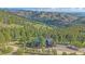 Aerial view showcasing the home nestled among trees with stunning mountain views at 25601 Centennial Trl, Golden, CO 80401