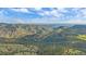 Expansive aerial view showcases rolling green mountains and distant city skyline at 25601 Centennial Trl, Golden, CO 80401