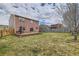 Backyard with a patio, grill, and grassy lawn, framed by a wooden fence at 303 Diablo Pl, Brighton, CO 80603