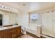 Bathroom featuring double sinks, a soaking tub and a walk-in shower at 303 Diablo Pl, Brighton, CO 80603