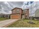 Two-story home with neutral siding and a well-manicured lawn and driveway at 303 Diablo Pl, Brighton, CO 80603