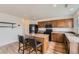 Well-lit kitchen features wooden cabinets, modern appliances, and an island with seating at 303 Diablo Pl, Brighton, CO 80603