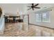 Open floor plan featuring wood floors, modern kitchen, dining area, and sliding door to backyard at 303 Diablo Pl, Brighton, CO 80603