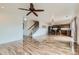 Open floor plan featuring wood floors, modern kitchen, dining area, and staircase at 303 Diablo Pl, Brighton, CO 80603