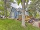 Beautiful backyard featuring a wooden deck, mature trees, lush green lawn, and a privacy fence at 11523 Sandy Creek Ln, Parker, CO 80138