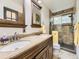 Bathroom featuring double sinks, a large mirror and shower with glass door at 11523 Sandy Creek Ln, Parker, CO 80138