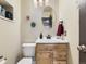 Cozy half-bathroom with a light wood vanity, round mirror, and toilet, offering functionality in a compact space at 11523 Sandy Creek Ln, Parker, CO 80138