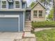 Charming home featuring blue wood siding, brick accents, a gray garage door and well-manicured landscaping at 11523 Sandy Creek Ln, Parker, CO 80138