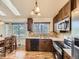 Charming kitchen featuring wood cabinets, stone backsplash, stainless steel appliances, and a window overlooking the yard at 11523 Sandy Creek Ln, Parker, CO 80138