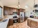 A spacious kitchen featuring wooden cabinetry, stainless steel appliances, tile backsplash, and bright, vaulted ceilings at 11523 Sandy Creek Ln, Parker, CO 80138
