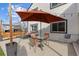 Inviting back patio with an outdoor umbrella, dining set, and string lights for relaxing or entertaining at 16402 E Tennessee Ave, Aurora, CO 80017